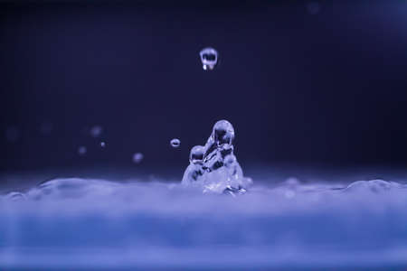 droplet fell into water with splash on dark  backgroundの写真素材