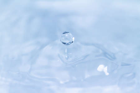droplet fell into water on blue backgroundの写真素材