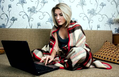 young happy smiling woman with laptop working at homeの写真素材