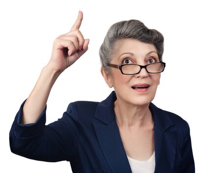 Happy aged woman pointing her finger upwardsの写真素材