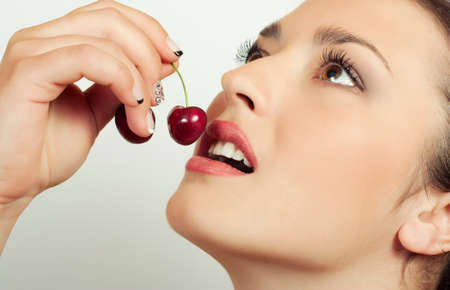 Sexy woman eating cherriesの写真素材
