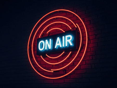 a vibrant on air neon sign glows against a brick wall, signaling a live broadcast from a radio station or podcast studioの素材