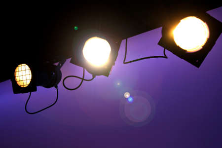 Three yellow stage light hanging on the ceiling