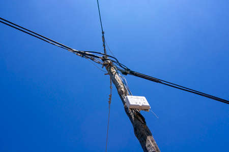 Looking up against a stressed wooden power pole. The sky is intens blue,の写真素材