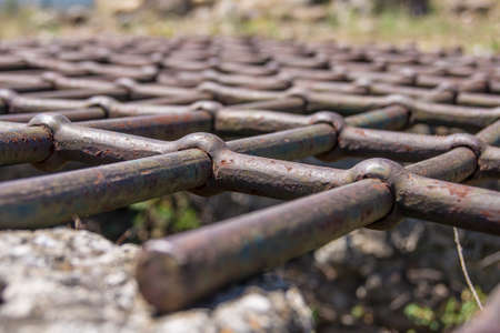 Closeup of an aged and stressed iron grate on a stone wellの写真素材
