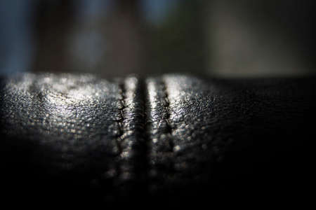 A close up of the leather of a black couch