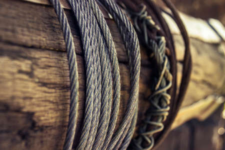 Some steel cables are rolled up on a old rustic water well somewhere at monastery in Romania