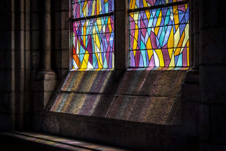 Stained glass in a church window creating beautiful colored spectrum of light.のeditorial素材
