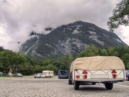 Cars and caravans are parked on a parking lot during a vacation in the mountainsの写真素材