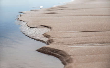 Textured wet sand on the beach made by water and windの写真素材