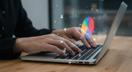 A person is analyzing business data on a laptop, with charts and graphs displayed on the screen, showcasing data visualization and performance analysis.の素材