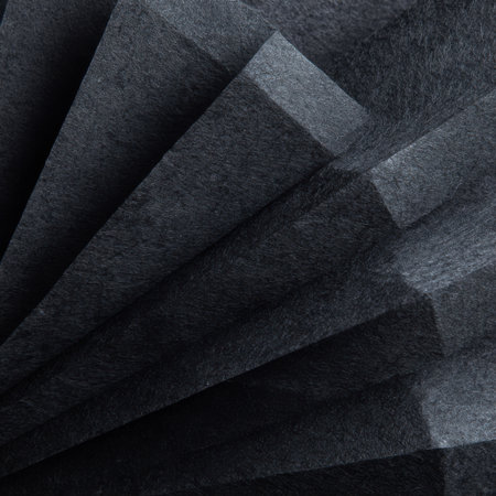 A detailed view of dark gray fabric with a subtle texture, folded into overlapping layers creating a sense of depth and shadow.の素材