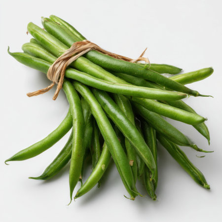 A bundle of vibrant green string beans, tied with natural twine, is presented against a clean white backdrop, highlighting their freshness and simplicity.の素材