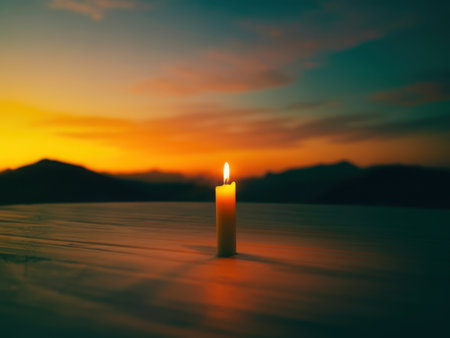 A solitary figure stands in a tranquil landscape holding a brightly lit candle. The warm glow illuminates the scene against a dramatic sunset sky with vibrant hues.の素材