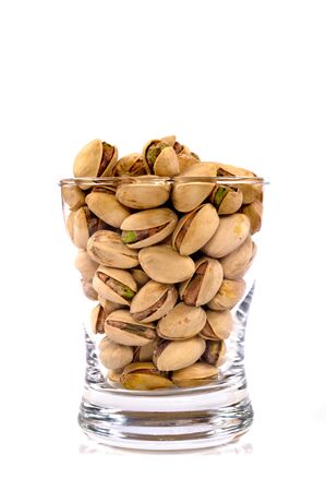 Glass of pistachios isolated on whiteの写真素材
