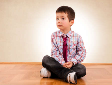 Little boy siting on the parquet の写真素材