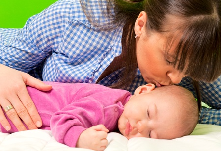 Mother kissing daughter for sweet dreamsの写真素材
