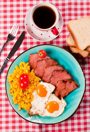 Fried eggs and pork meat on the plate from aboveの写真素材