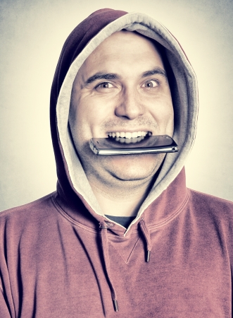 Funny man eating his cell phoneの写真素材