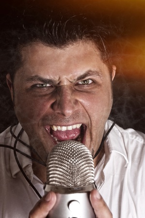 Angry singer with the mic. Selective focus on the man headの写真素材