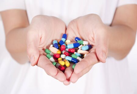 Bunch of pills in female hands. Selective focus on the front pills in handsの写真素材