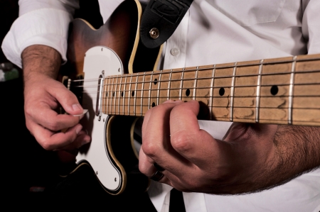 Man playing his guitar in low key