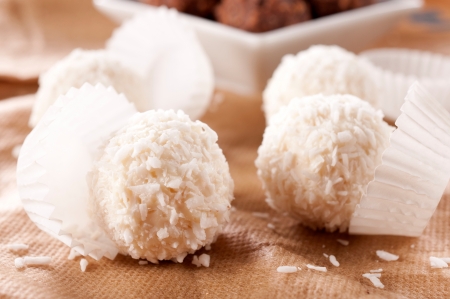 Spashed coconut and pralines on table の写真素材