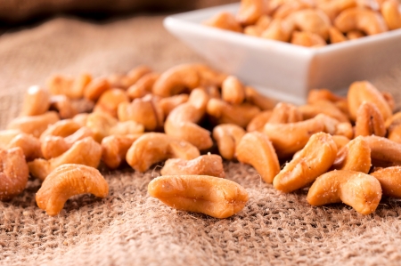 Pile of roasted cashew nuts splashed on the tableの写真素材