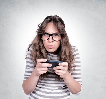 Angry female holding the mobil phone. Selective focus on the femaleの写真素材