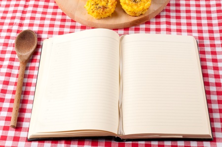 Blank cookbook and wooden ladle on the table の写真素材