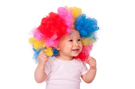 Happy baby girl with clown wig isolated on white の写真素材