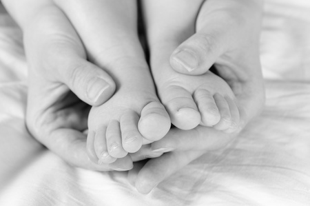 Mother holding baby feet. Selective focus on the baby feet の写真素材