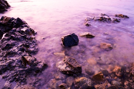 Stones and purple sea water in the long exposureの写真素材