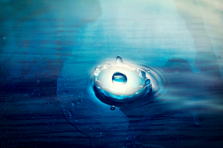 Light blue planet droping into the water の写真素材