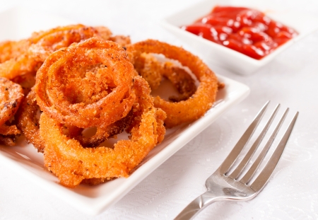 Deep fried homemade onion rings on the plate.Selective focus on the onion ringsの写真素材