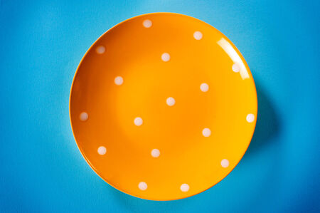 Empty yellow plate on the light blue background, from aboveの写真素材