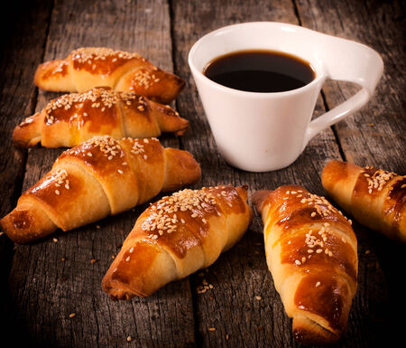 Homemade stuffed mini croissants and dark coffee