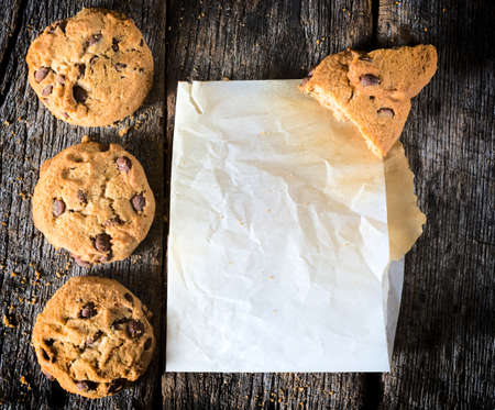 Chip cookies and blank wrinkled paper on the wooden table,from above の写真素材