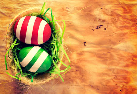 Easter eggs in the basket on paper background with blank space on right sideの写真素材