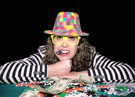 Female holding poler chip in her mouth.Selective focus on the female の写真素材