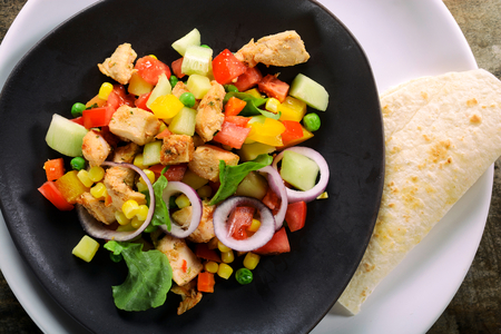 Chicken salad and tortilla bread on the plate from aboveの写真素材