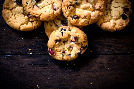 Dry cranberries cookies on the wooden background with blank space