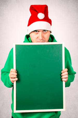 Angry Santa holding blank green chalk boardの写真素材