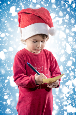 Little child holdin Christmas wish list in his handsの写真素材