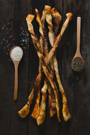 Pastry sticks with sesame and chime on wooden background