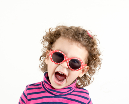 Positive child with retro sunglasses showing her happinesの写真素材