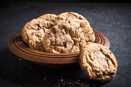 Homemade chocolate chip cookies in the wooden plate,selective focusの写真素材