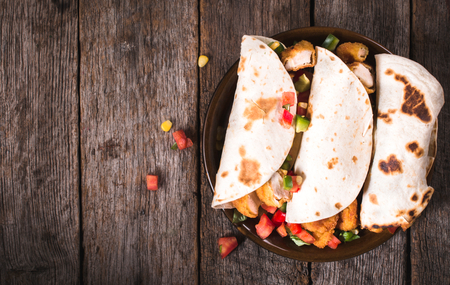Chicken wrap sandwiches in the plate on wooden background,selective focus and blank spaceの写真素材
