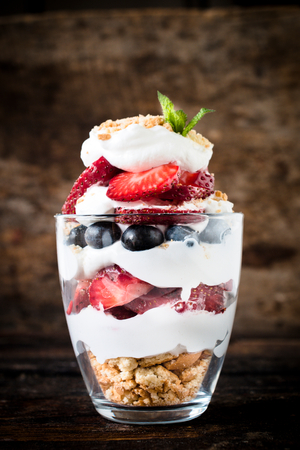 Sweet dessert in glass with biscuit,berry fruit and vanilla cream,selective focusの写真素材