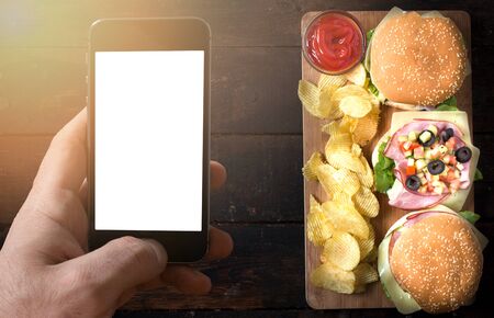 Blank screen on smart phone and sandwiches with potato chips,take away concept